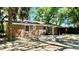 Brick home featuring an open yard, with large trees, and a covered patio at 1521 Camp Rd, Charleston, SC 29412