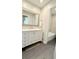 Bathroom vanity with a large mirror, gray tile floor, and a door leading to the shower and toilet at 1521 Camp Rd, Charleston, SC 29412