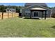 Fenced backyard with manicured green lawn, covered patio, and an outdoor firepit at 167 Cypress Plantation Rd, Moncks Corner, SC 29461