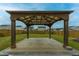 Backyard features a covered pergola with string lights, concrete pad, and manicured lawn at 167 Cypress Plantation Rd, Moncks Corner, SC 29461