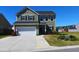 Charming two-story home featuring a two-car garage, manicured lawn, and vibrant flower beds adding curb appeal at 167 Cypress Plantation Rd, Moncks Corner, SC 29461