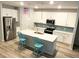 Modern kitchen featuring white cabinets, an island with bar seating, stainless steel appliances, and stylish pendant lighting at 167 Cypress Plantation Rd, Moncks Corner, SC 29461