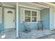 Light blue home's front porch with chairs offers a cozy spot to relax and enjoy the outdoors at 184 Tabby Creek Cir, Summerville, SC 29486