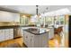 Open kitchen features white cabinets, granite countertops and a center island with gas cooktop at 1855 Cherokee Rose Cir, Mount Pleasant, SC 29466
