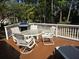 Back porch deck with a glass table, patio chairs, a grill, and a lounge chair overlooking a lawn at 1855 Cherokee Rose Cir, Mount Pleasant, SC 29466