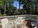Back porch deck with a glass table and patio chairs overlooking a treelined lawn at 1855 Cherokee Rose Cir, Mount Pleasant, SC 29466