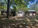 View of the back of the home and the backyard which has mature trees and a small shed in the distance at 1866 Ashley Hall Rd, Charleston, SC 29407