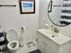 Clean bathroom features a modern vanity, toilet and round mirror over a white sink at 1866 Ashley Hall Rd, Charleston, SC 29407