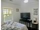 Bright bedroom with a window view and a TV on a stylish black console table at 1866 Ashley Hall Rd, Charleston, SC 29407