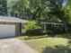 Traditional brick home featuring a two-car garage and well-manicured lawn and lots of shade trees at 1866 Ashley Hall Rd, Charleston, SC 29407