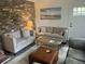 Cozy living room featuring exposed brick wall, modern sofas, and beach-themed artwork at 1866 Ashley Hall Rd, Charleston, SC 29407