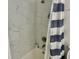 Shower with grey and white marble-patterned tiles and showerhead at 1866 Ashley Hall Rd, Charleston, SC 29407