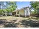 The home's exterior features a chimney, window, and steps down to the spacious backyard with lush trees at 195 Edinburgh St, Summerville, SC 29483