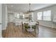 Bright dining area adjacent to the kitchen features a round table, chandelier, and hardwood floors at 207 Winding River Dr, Johns Island, SC 29455