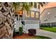 Inviting townhome featuring a two-car garage and charming staircase, complemented by lush landscaping at 207 Winding River Dr, Johns Island, SC 29455