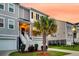 Charming home exterior featuring a well-manicured lawn and tropical palm trees at sunset at 207 Winding River Dr, Johns Island, SC 29455
