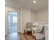 Hallway with hardwood floors, two upholstered chairs, table with lamp, and a doorway to a bedroom at 207 Winding River Dr, Johns Island, SC 29455