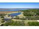 An aerial view of a scenic golf course with a beautiful blue lake and lush green trees surrounding the water at 2131 Pentland Dr, Charleston, SC 29412