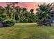 Expansive backyard featuring lush green grass and mature trees offers plenty of space for outdoor activities and relaxation at 2131 Pentland Dr, Charleston, SC 29412