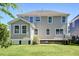 Exterior of back of home with new siding and windows, green grass, and a small patio space at 2131 Pentland Dr, Charleston, SC 29412