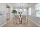 Bright dining room with modern chandelier, multiple windows and view of white kitchen cabinets at 2131 Pentland Dr, Charleston, SC 29412