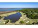 Aerial view of golf course with lush green fairways, serene lake, and surrounding mature trees, enhancing the community's outdoor appeal at 2131 Pentland Dr, Charleston, SC 29412