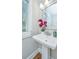 A bathroom featuring a white pedestal sink, elegant faucet, and a mirror with a decorative frame at 2130 Weaver St, Charleston, SC 29403