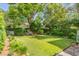 Lush backyard with mature trees offers a private retreat with ample space for outdoor activities and relaxation at 23 Savage St, Charleston, SC 29401