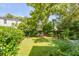 A lush green backyard offers a serene escape with mature trees and a cozy bench nestled in the grass at 23 Savage St, Charleston, SC 29401