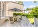 Outdoor seating area on a charming white balcony features a decorative umbrella and view of yard at 23 Savage St, Charleston, SC 29401