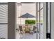Cozy outdoor dining area on a charming white balcony, framed by an open doorway for relaxed entertaining at 23 Savage St, Charleston, SC 29401