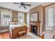 Cozy bedroom with a decorative fireplace, complemented by light-filled windows and hardwood floors at 23 Savage St, Charleston, SC 29401