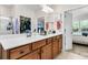 Spacious bathroom with double vanity, large mirror, and walk-in closet and bedroom doorway in view at 239 Sea Lavender Ln, Summerville, SC 29486