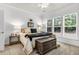 Bright bedroom showcasing large windows, neutral walls, and a decorative chest at the foot of the bed at 239 Sea Lavender Ln, Summerville, SC 29486