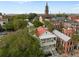 Scenic aerial view of a neighborhood featuring houses, lush trees, and a historic steeple at 24 Chalmers St, Charleston, SC 29401
