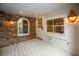 Inviting covered back porch boasts white-painted wood floors and stylish sconces, seamlessly blending indoor comfort with outdoor charm at 24 Chalmers St, Charleston, SC 29401