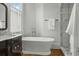 Bathroom featuring a soaking tub, dark wood vanity, and walk-in shower, creating a spa-like retreat at 24 Chalmers St, Charleston, SC 29401