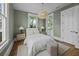 Serene bedroom with pendant lighting, hardwood floors, and ensuite balcony access at 24 Chalmers St, Charleston, SC 29401
