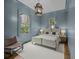 Blue bedroom featuring a large bed, wood floors, chair and two large windows providing ample natural light at 24 Chalmers St, Charleston, SC 29401