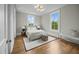 Bright bedroom with hardwood floors, two windows, and stylish modern lighting fixture at 24 Chalmers St, Charleston, SC 29401