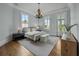 Serene bedroom featuring a chandelier, neutral decor, and natural light from windows at 24 Chalmers St, Charleston, SC 29401