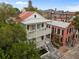Charming white home featuring double balconies, a red roof, and verdant surroundings at 24 Chalmers St, Charleston, SC 29401