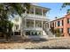 Elegant two-story home boasting a charming double porch, symmetrical columns, and well-manicured landscaping at 24 Chalmers St, Charleston, SC 29401