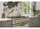 Close up of kitchen showcases marble counters, a chef's range, and custom cabinets with brass hardware at 24 Chalmers St, Charleston, SC 29401