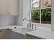 Sunlit kitchen sink with white countertops and a bright view from the window at 24 Chalmers St, Charleston, SC 29401