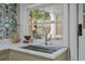 Wet bar features a stainless steel sink, gooseneck faucet, and a view of the patio through the window at 24 Chalmers St, Charleston, SC 29401