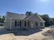 Charming single-story home featuring a covered porch and classic gray siding at 250 Dandelion Ct, Round O, SC 29474