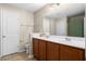 Bright bathroom boasts a dual sink vanity, a tiled floor, and a shower-tub combo with a curtain at 2505 Stadium Dr, North Charleston, SC 29406