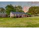 Charming brick home with manicured lawn and lush landscaping at sunset at 2506 Birkenhead Dr, Charleston, SC 29414