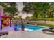 Relaxing backyard pool oasis with lounge seating, lush landscaping, and colorful ambient lighting at 2506 Birkenhead Dr, Charleston, SC 29414